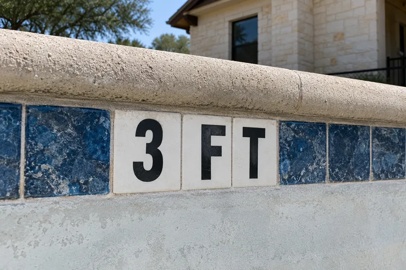 Depth marker tiles set just below the coping of a community pool