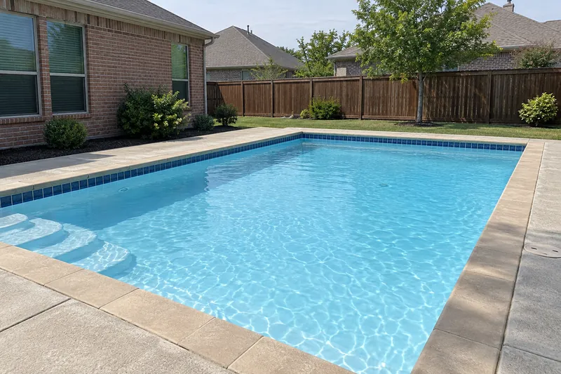 Freshly replastered backyard pool with smooth white plaster and light blue water
