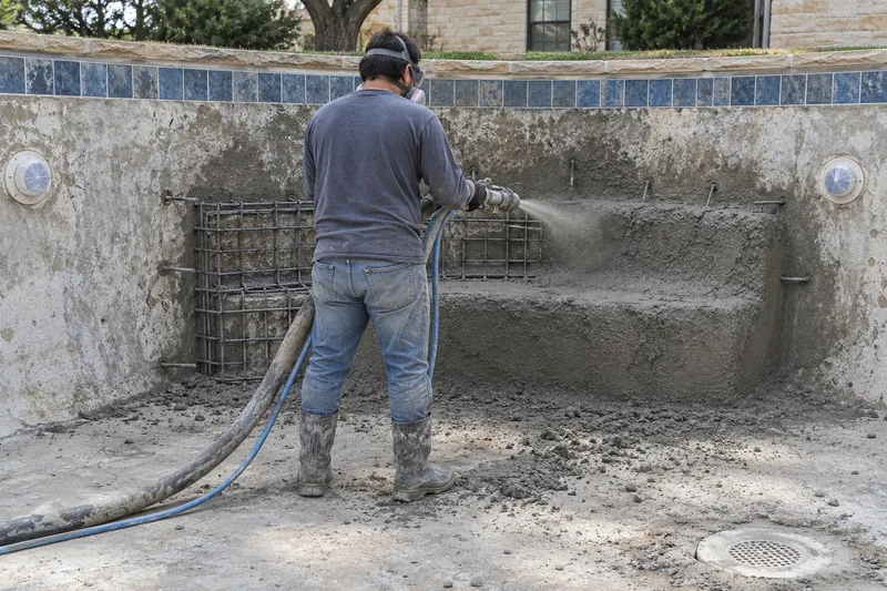 Gunite sprayed onto rebar for a new bench against an old pool wall